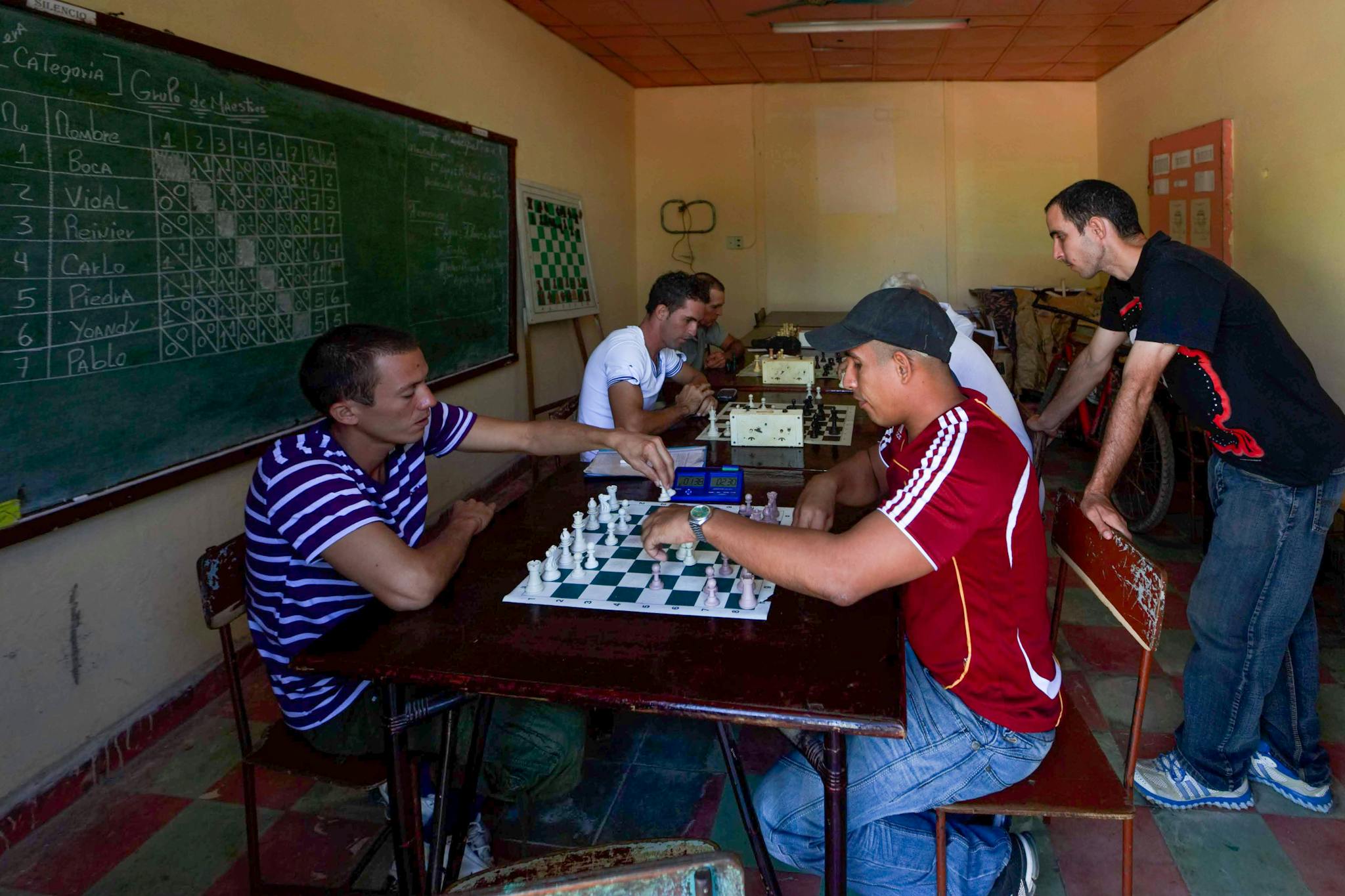 Casual gaming scene of adults playing chess indoors, creating a focused atmosphere.